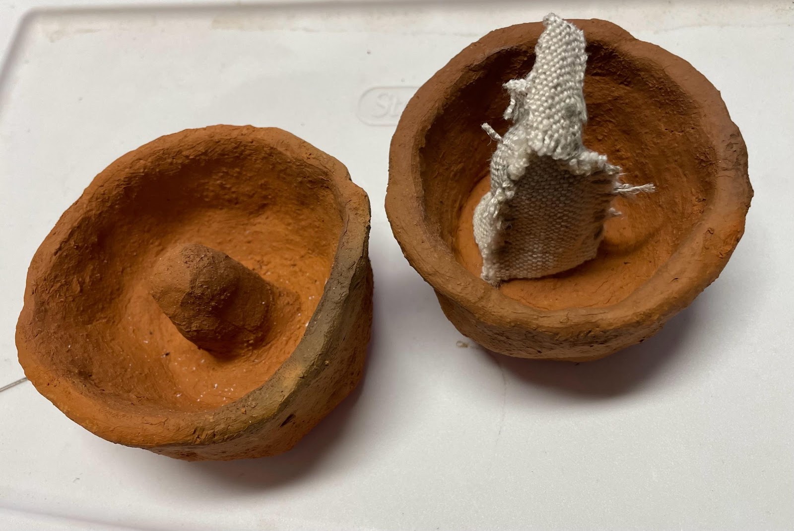 A clay pots with a piece of cloth inside

AI-generated content may be incorrect.