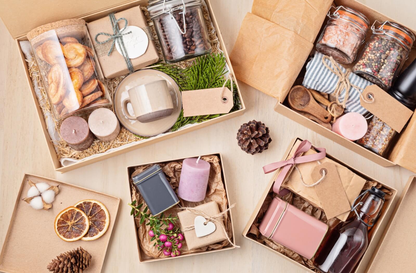 A flatlay display of assorted gift boxes containing coffee beans, pastries, candles, a mug, and other related gifts.