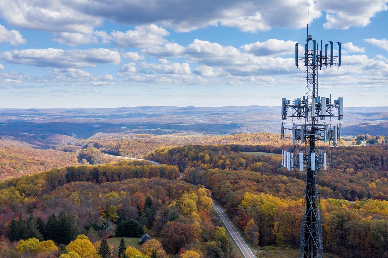 A tower with many antennas in the middle of a forest

Description automatically generated