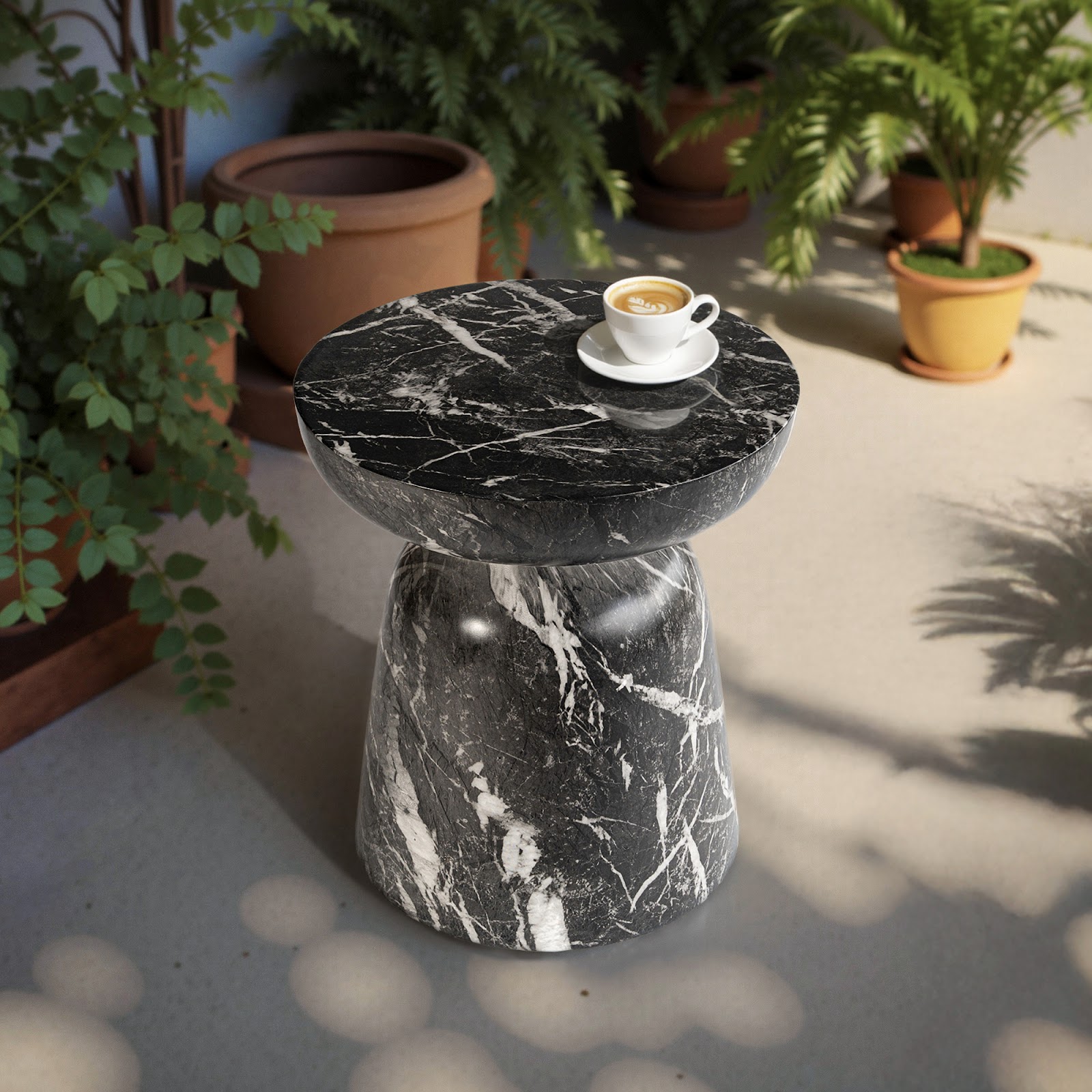 Grover Outdoor Faux Marble Goblet Side Table with a rounded top and flared base in dramatic black marble-look finish, styled with a coffee cup on a shaded patio—ideal for adding sculptural flair to contemporary outdoor seating areas.