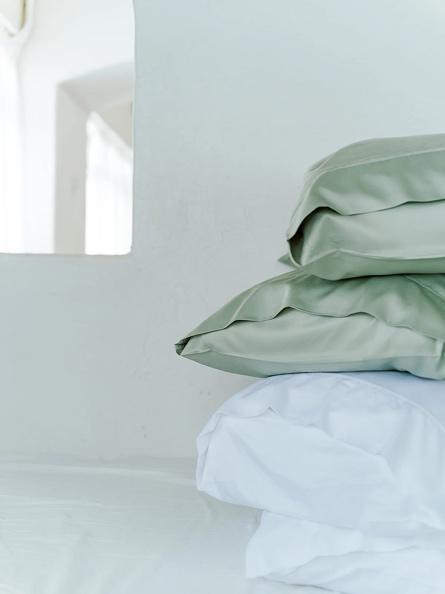 A stack of pillows and blanketsDescription automatically generated