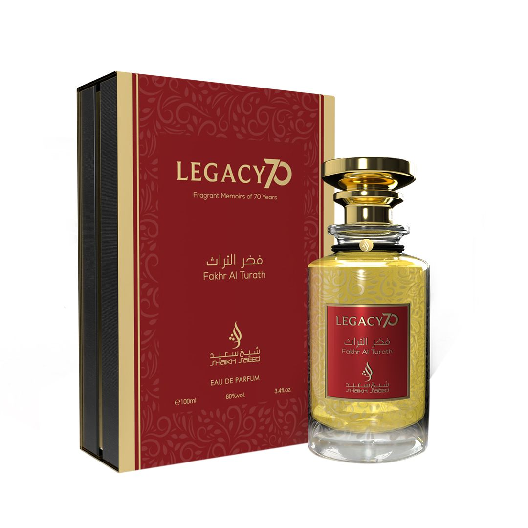 Shaikh Saeed Fakhr Al Turath Legacy 70 perfume bottle with a gold cap, placed next to its elegant red and gold packaging, featuring Arabic text and floral designs.