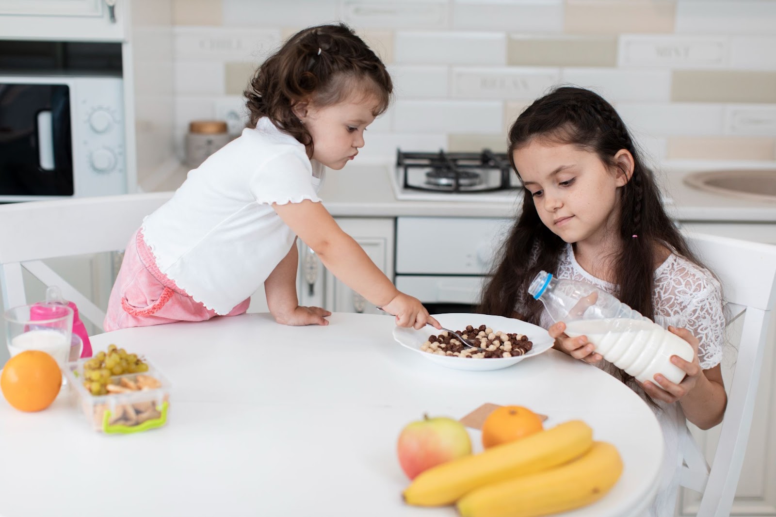 Two kids eating snacks that are listed as healthy snack  ideas for kids.