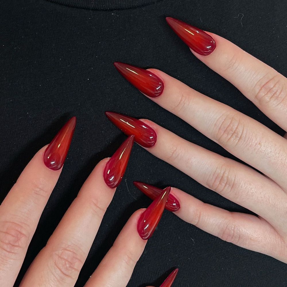 Close up of hands having Christmas red nails with Stiletto Red Vine Nails