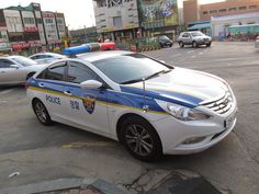 This contains a picture of a korean police car parked on the side of the road