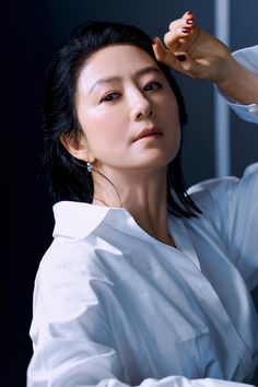 Kim Hee Ae on a with cloth with her her finger on her fore head 