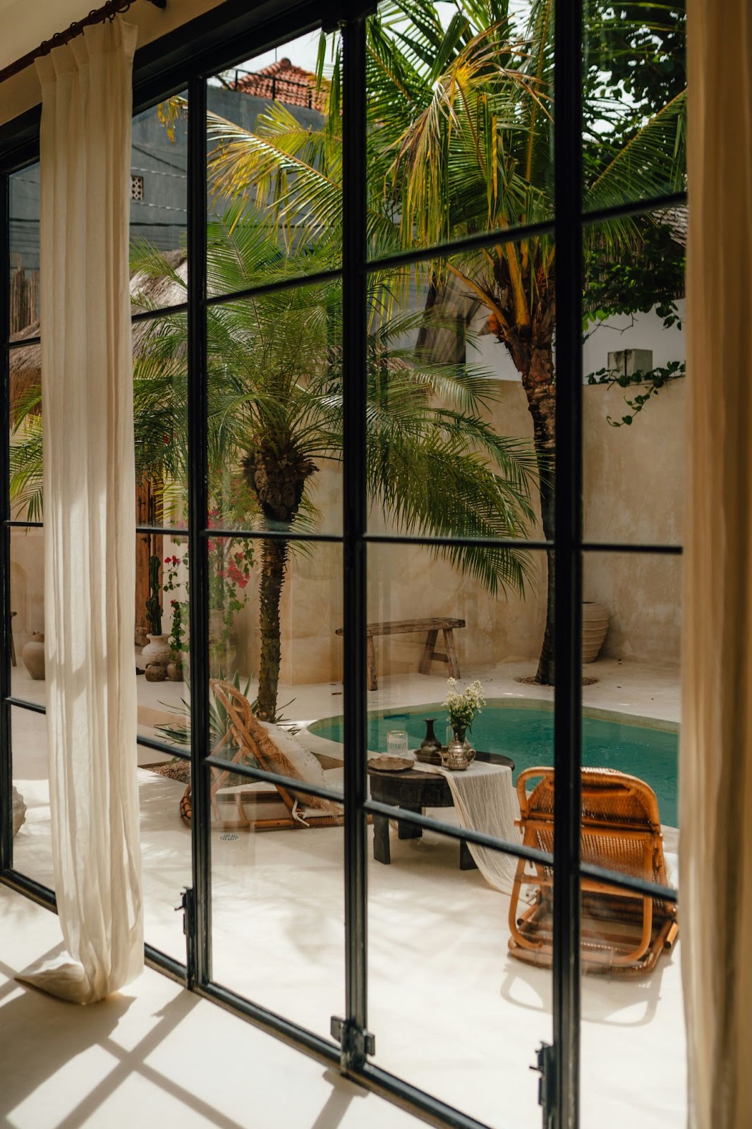 A view from inside a house looking outside to a inground pool.