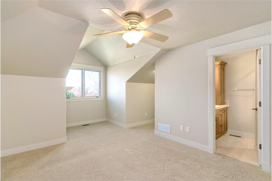 Another bedroom with carpet flooring, vaulted ceiling, and a private bath.