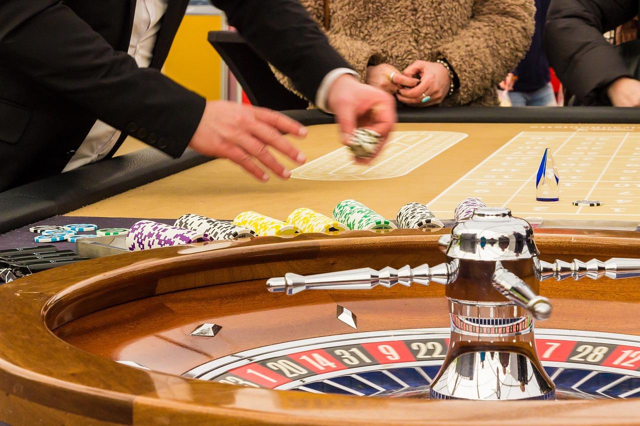 A roulette table with a group of people in the background

Description automatically generated