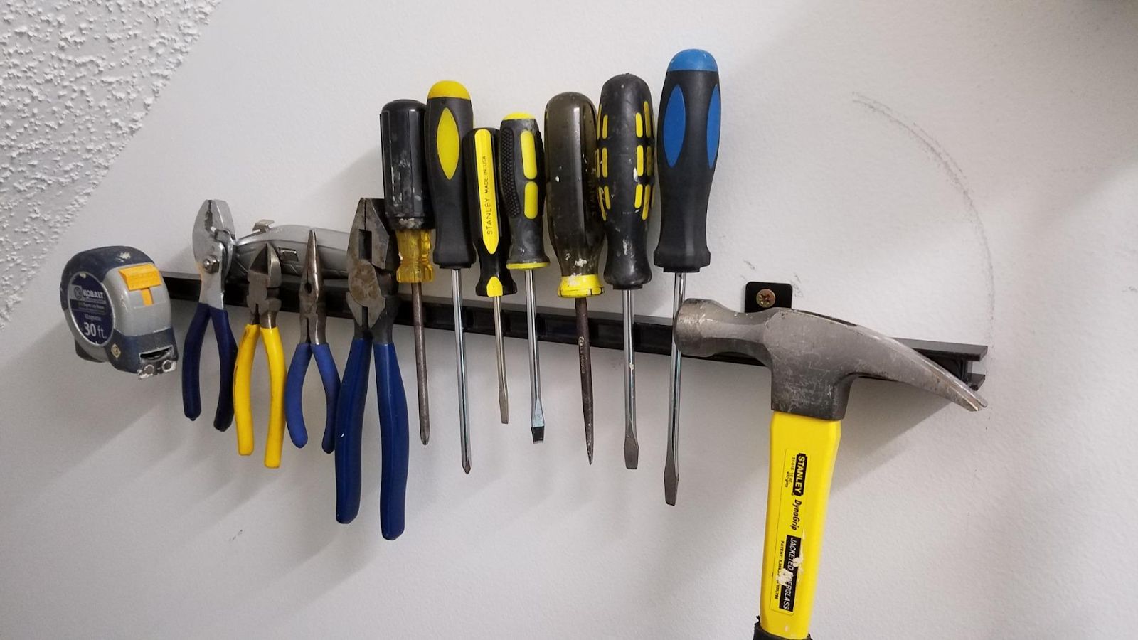 Magnetic strips installed on the wall with small metal tools.  It is one of the 7 garden storage hacks every gardener should know.