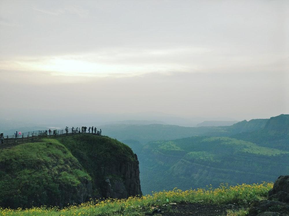 people standing on cliff