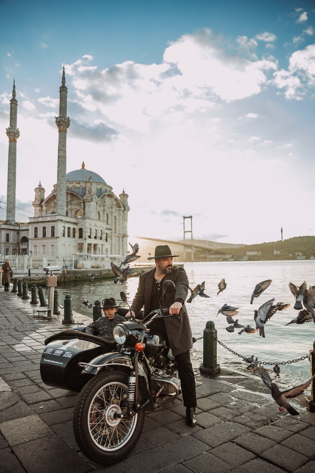 Sunrise ride at Ortaköy — father, son, and pigeons over the bridge.