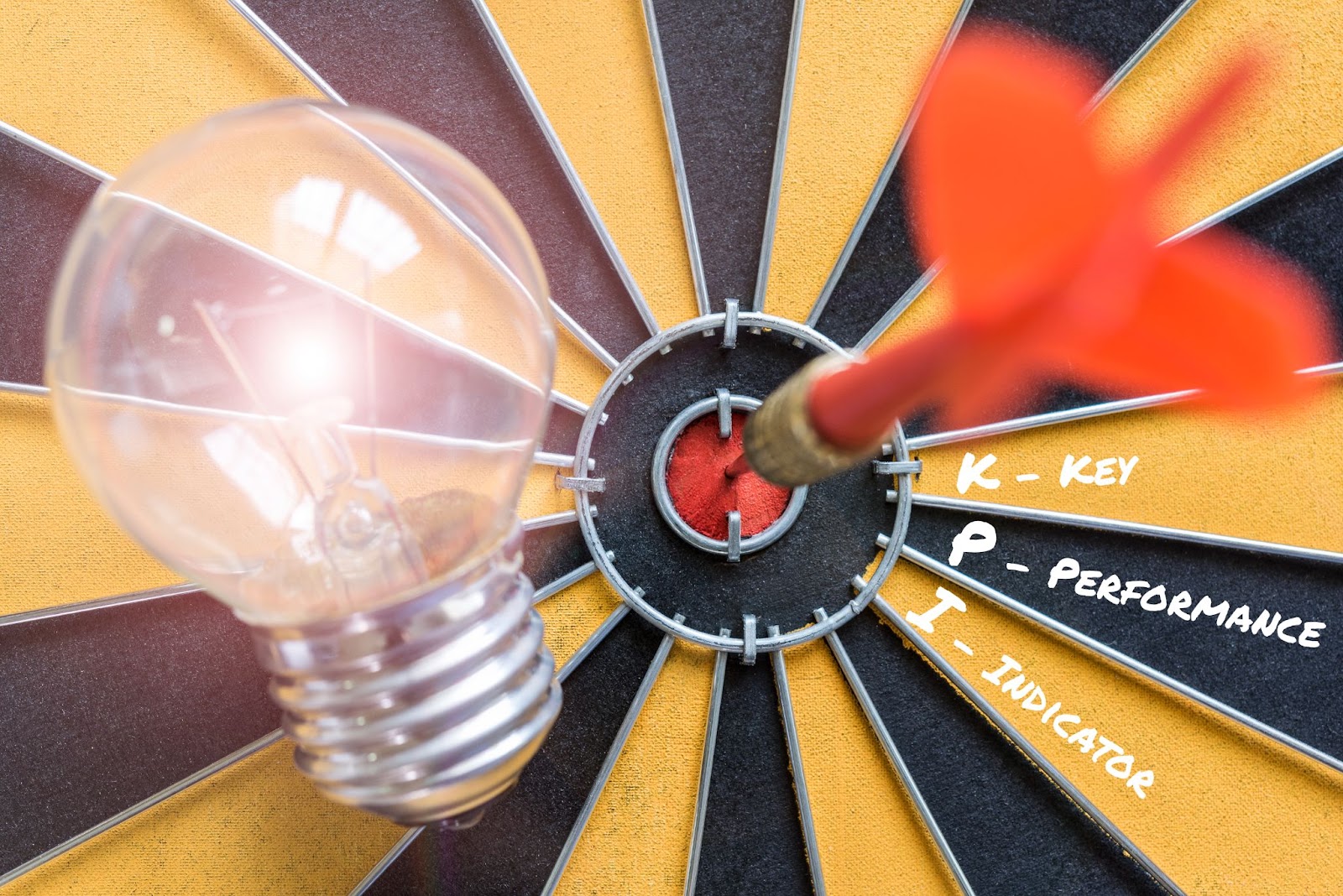 Bullseye with KPI text, lightbulb, and dart symbolizing goal setting and performance tracking.