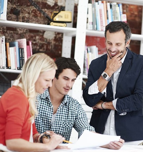 three people looking at the paper 