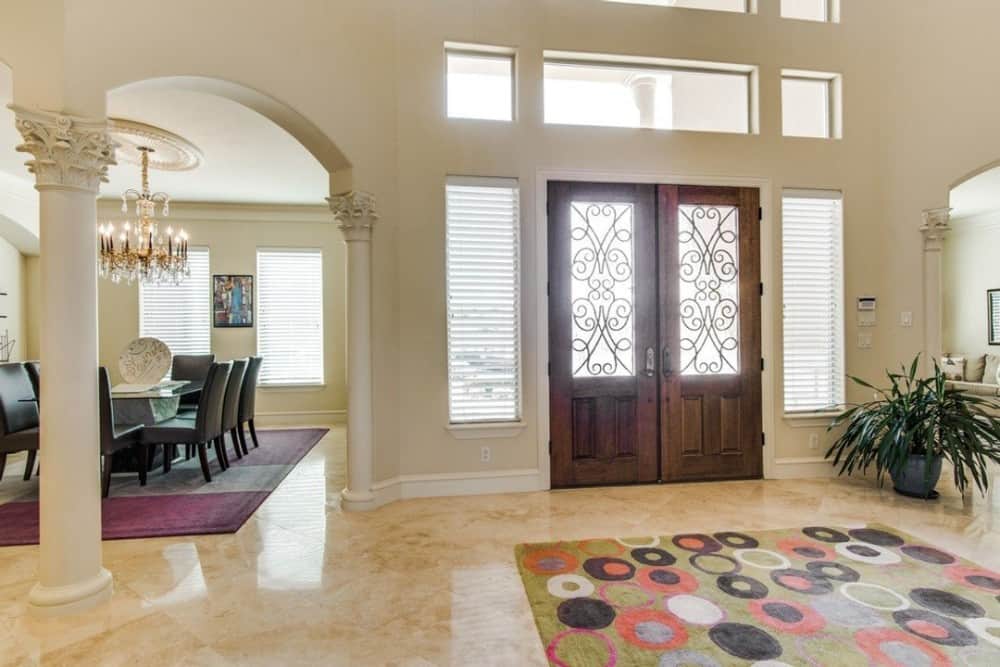 Foyer with a patterned area rug and a french entry door bordered by sidelights and transoms.