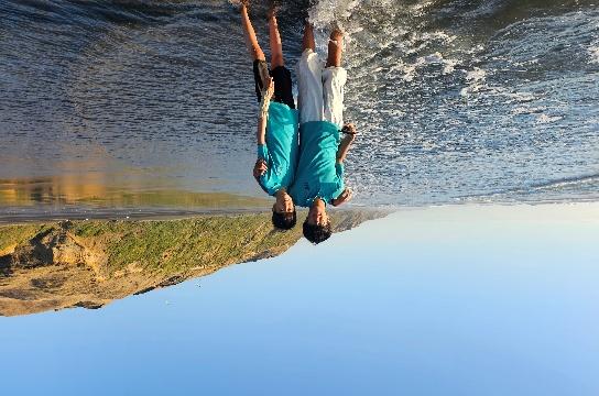 Two people standing in the water AI-generated content may be incorrect.