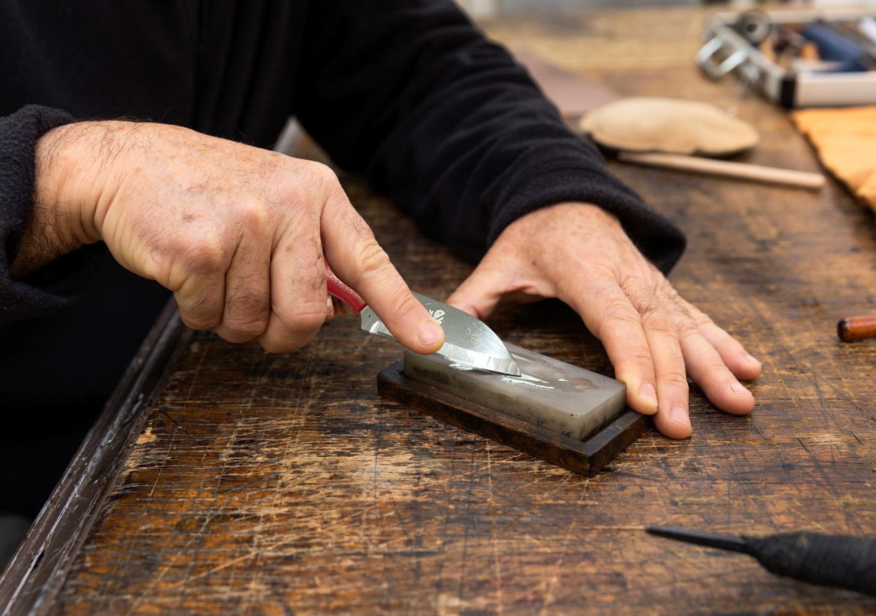 Dengan pisau di tangan, seorang pria memotong kayu