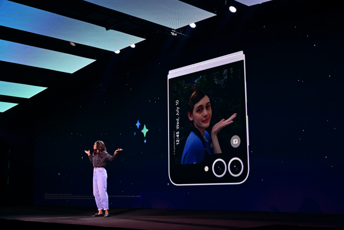 A person on stage with a screen

Description automatically generated