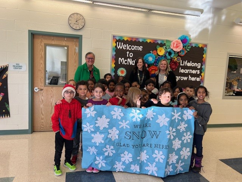 Dr. Reid with a group of students holding 