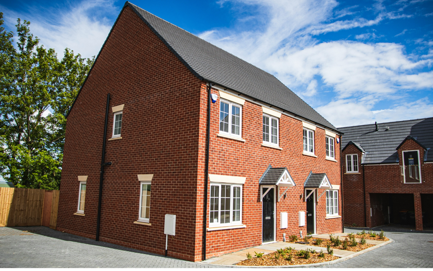 A brick house with a black roofDescription automatically generated