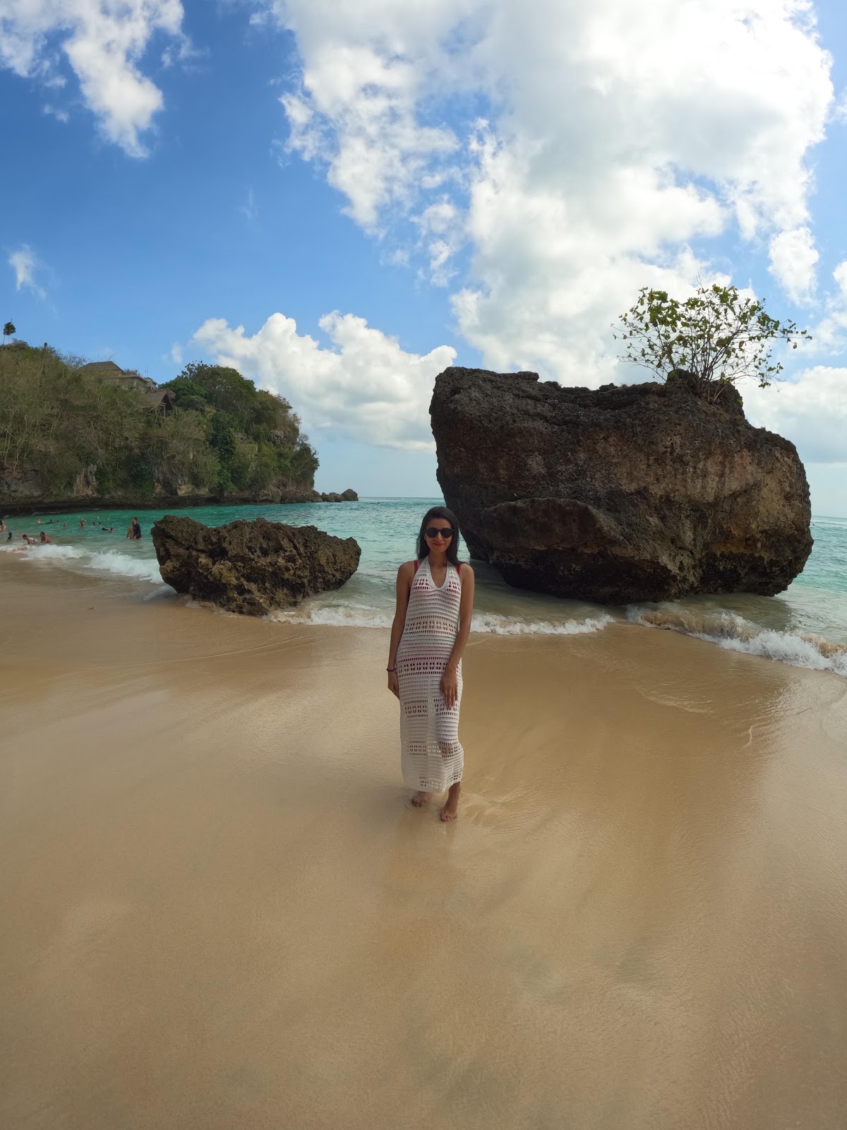 beautiful white sand beach with large boulders and blue water in uluwatu,bali 