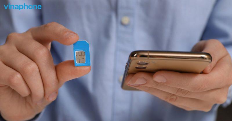 A person holding a small sim card

Description automatically generated