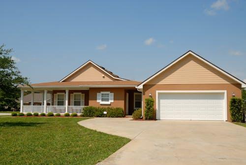 Free Beautiful modern suburban house with a spacious driveway and green lawn, perfect for families. Stock Photo