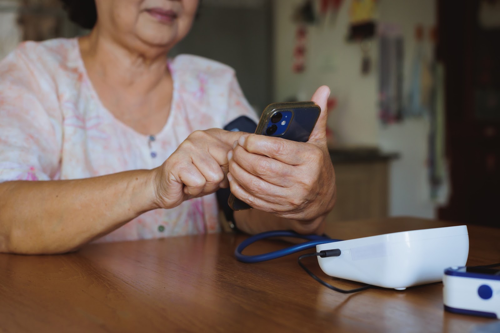 Elderly woman using remote patient monitoring devices and her smart phone