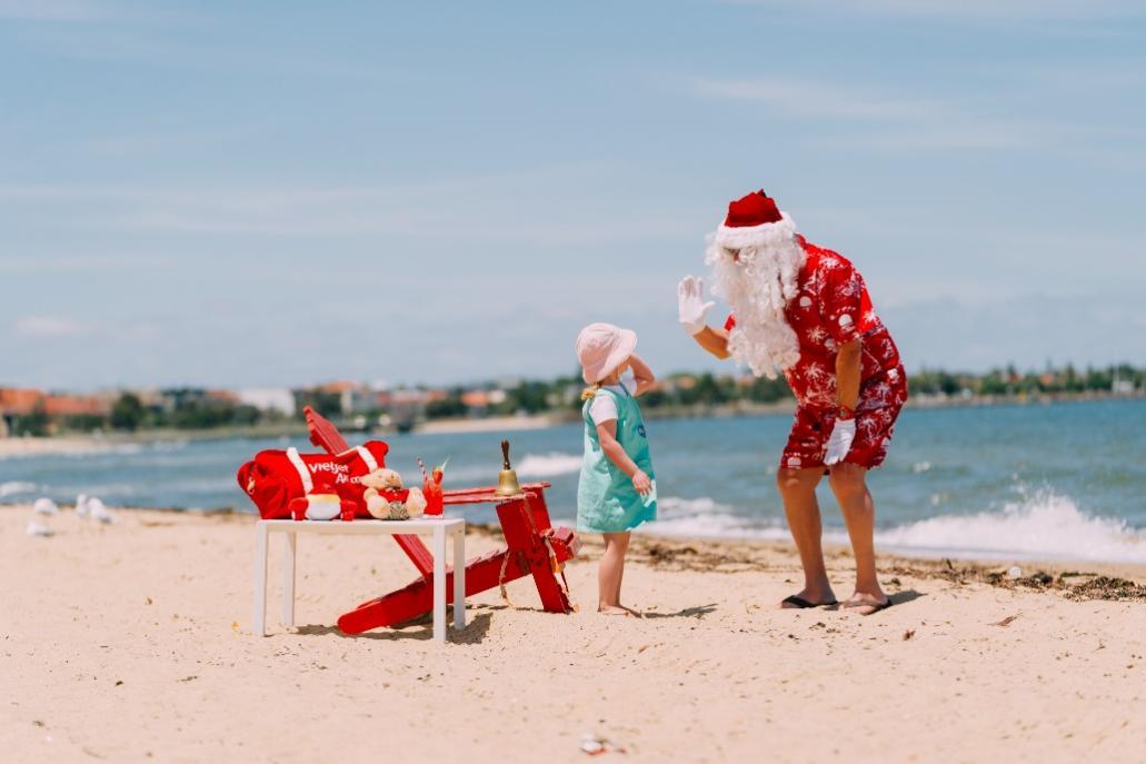 A person and child on a beach Description automatically generated