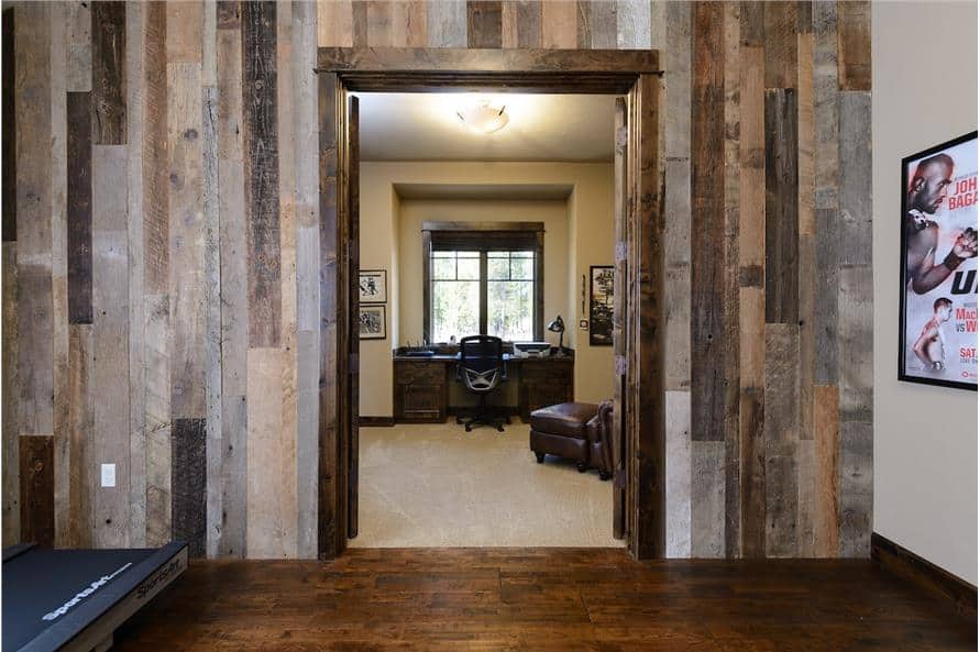 Exercise room with wood-paneled walls and a double door that opens to the study.