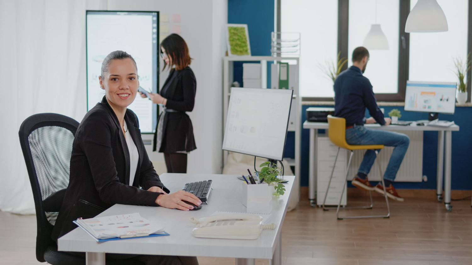 A diverse team of happy and productive employees working comfortably in an ergonomically designed open-plan office.