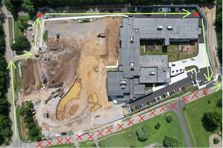 Aerial view of a building with a road and a parking lot AI-generated content may be incorrect.