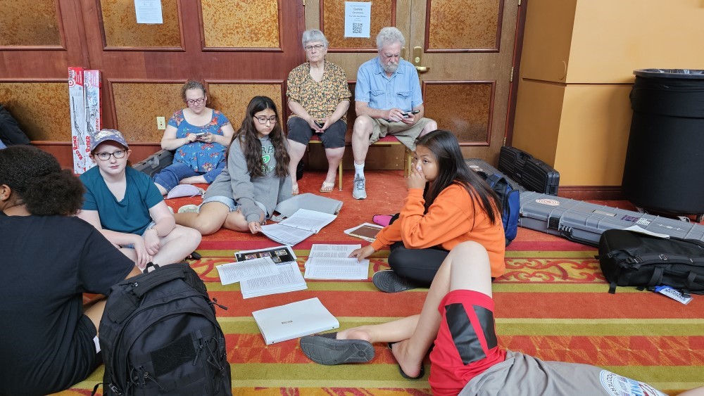 Children sitting on the floor reading manuals preparing for the written test. 