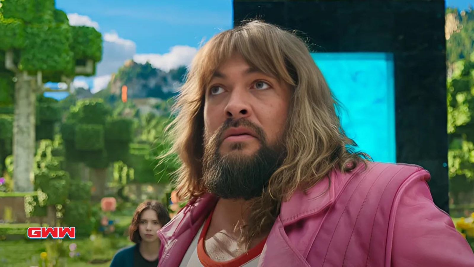 Jason Momoa in pink jacket in a lush, Minecraft-themed world