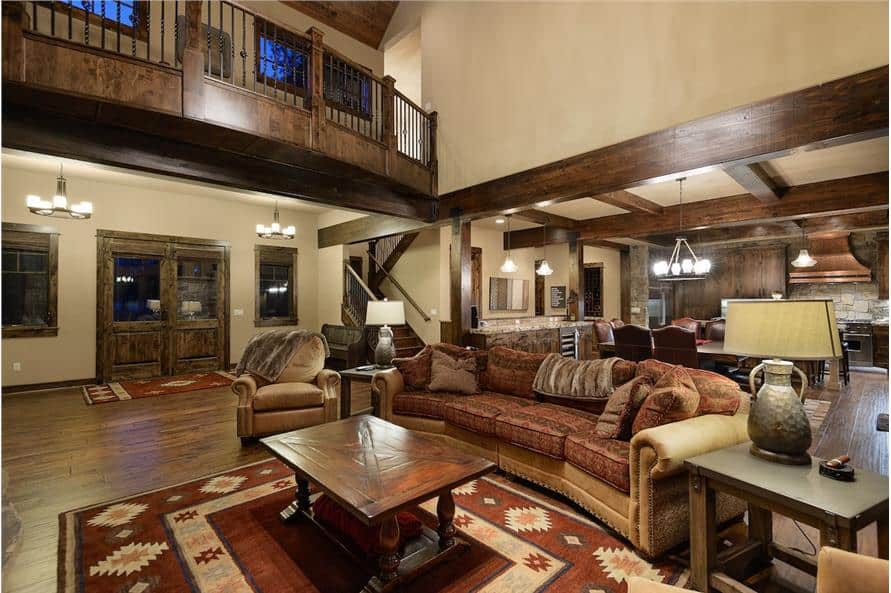 Great room with leather seats and a wooden coffee table sitting on a patterned area rug.