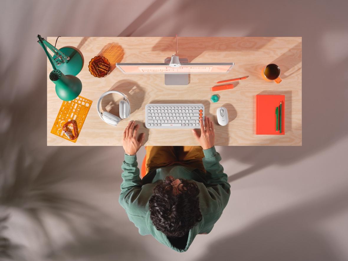 A person sitting at a desk using a computer

Description automatically generated