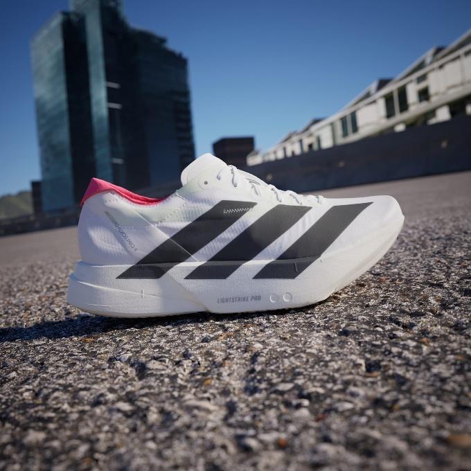 A white shoe with black stripes on it

Description automatically generated