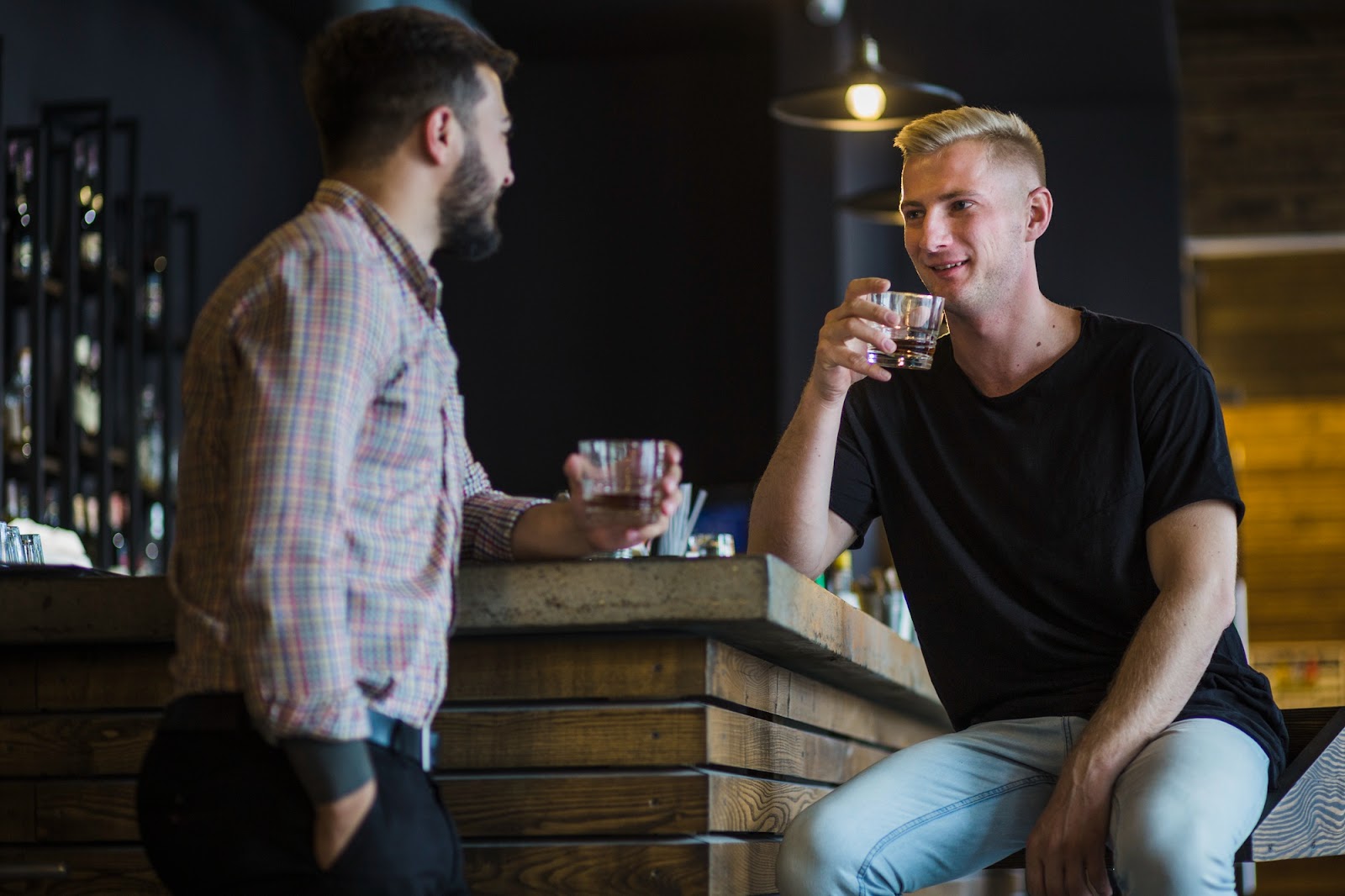 Two male friends having drinks at night in a bar | Source: Freepik