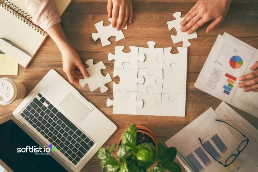 Hands assembling a puzzle on a table with office supplies.