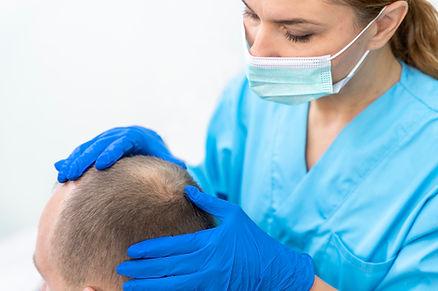 A surgeon is doing a scalp examine of his patient 