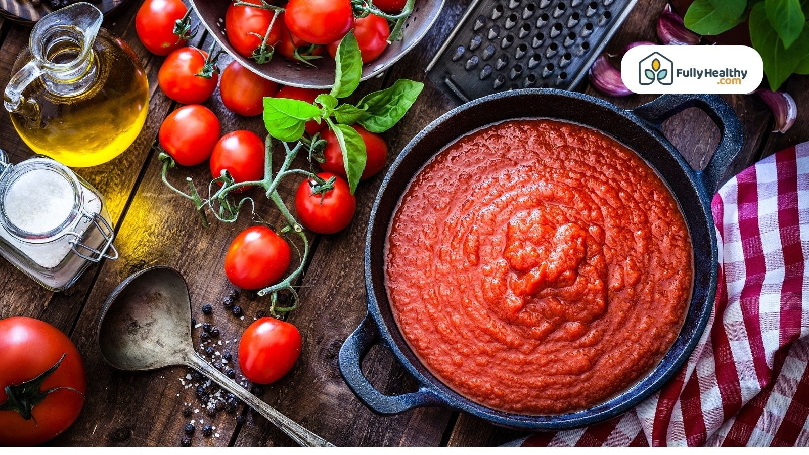 Cast iron skillet with tomato sauce surrounded by fresh ingredients