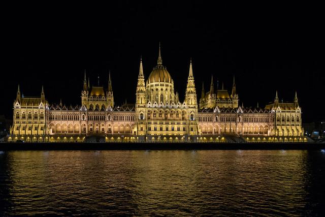 Hungarian Parliament Building with a large building and a body of water AI-generated content may be incorrect.