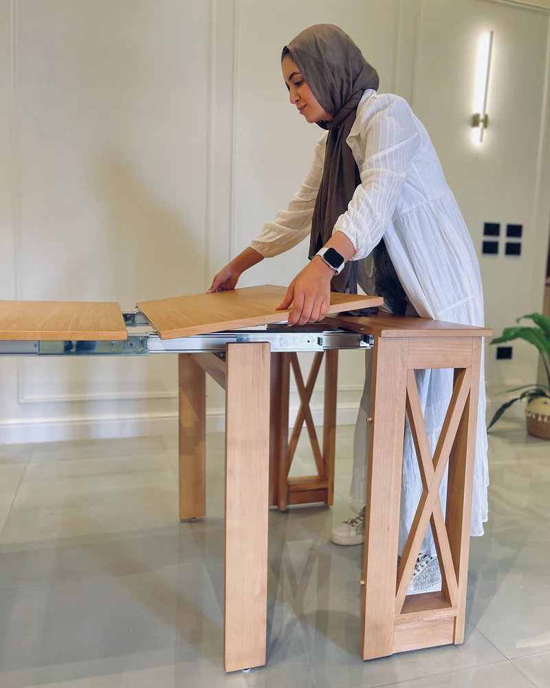 A person in a white dress and scarf cutting a table

AI-generated content may be incorrect.