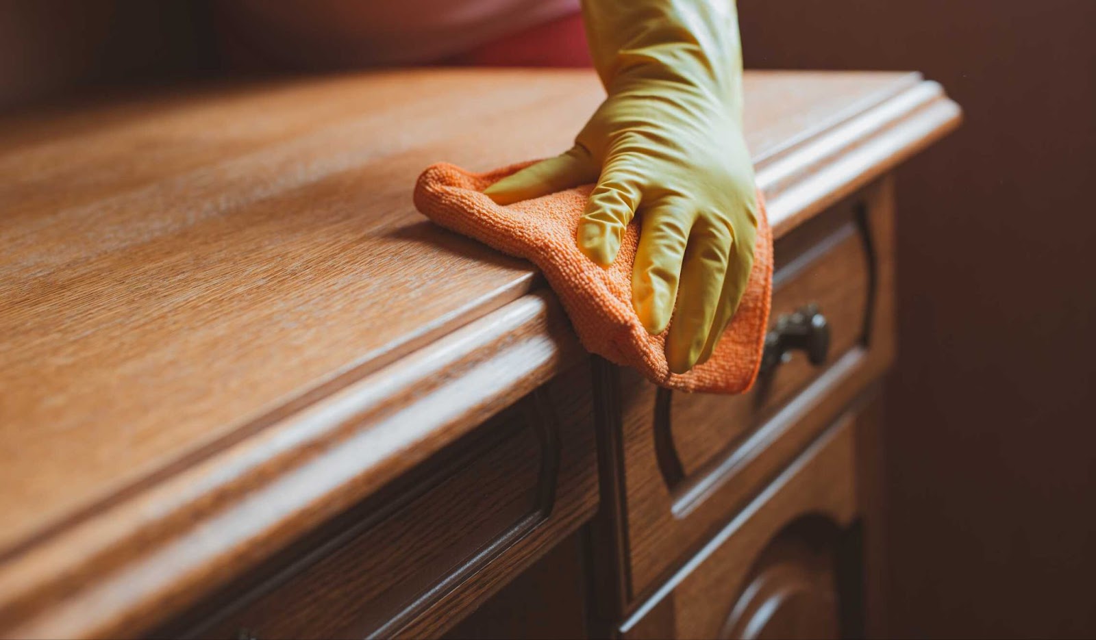 Image of a person cleaning wood furniture