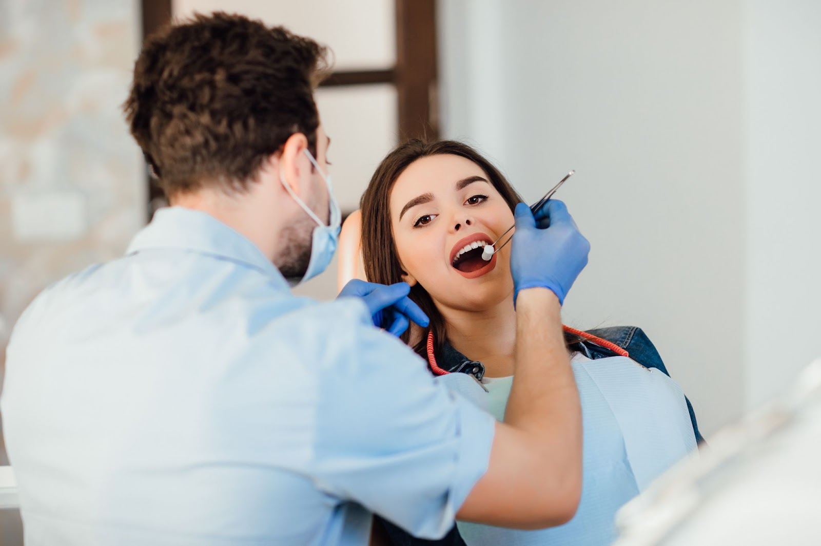 Dentist examining a female patient’s gums for signs of gum disease during a dental check-up.