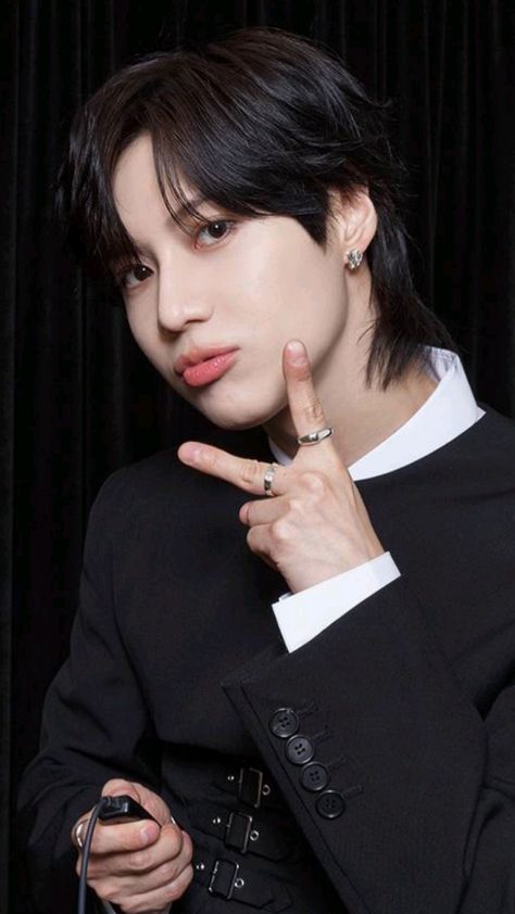 This contains an image of SHINee's Taemin with black hair pointing at his finger