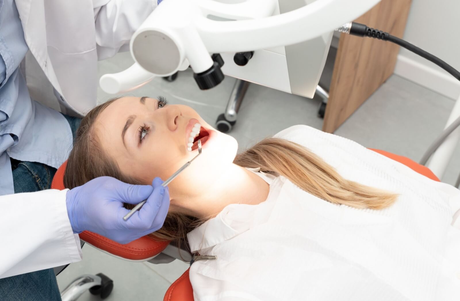 A dentist performs a thorough dental exam on a patient, looking for any signs of infection or abscessed teeth.