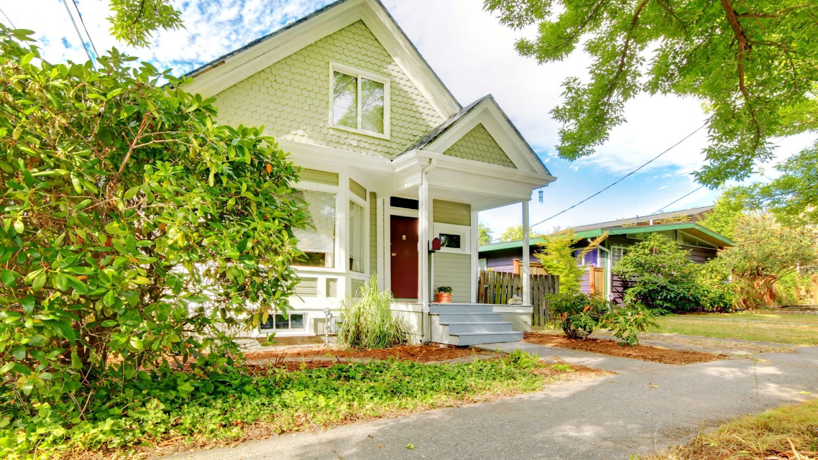 An image of a charming ancestral home surrounded by lush greenery and a vibrant garden