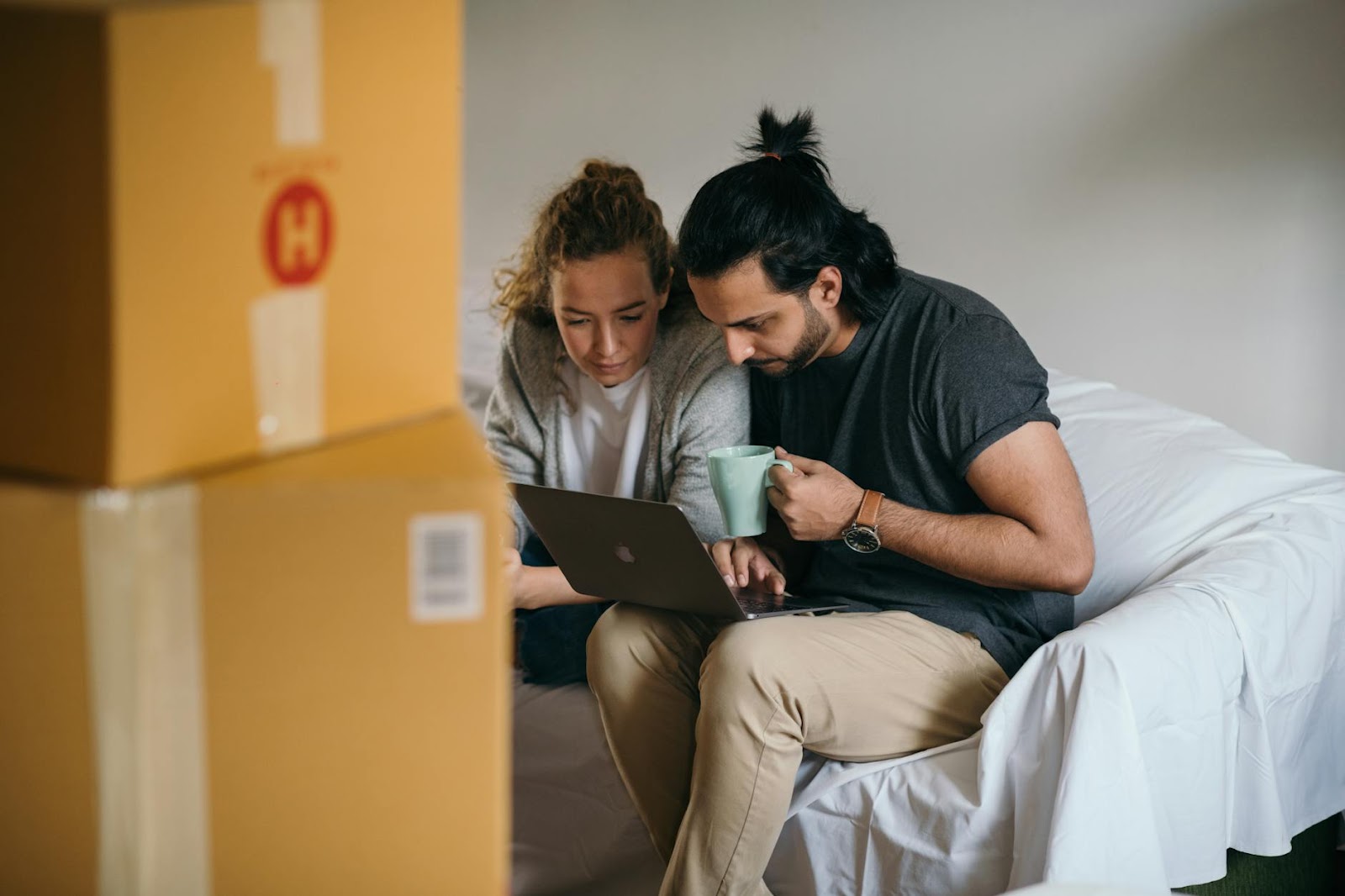 https://www.pexels.com/photo/young-multiethnic-couple-watching-laptop-while-moving-house-4247733/