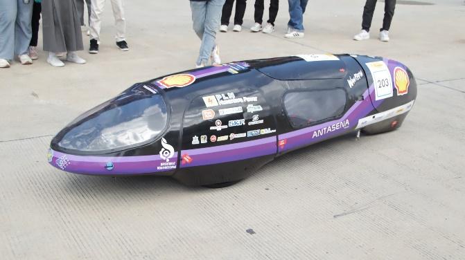 A black and purple vehicle with white stickers on it

Description automatically generated